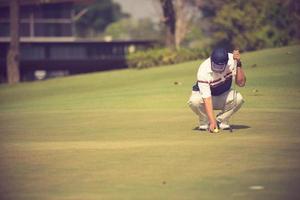 pro golfspeler gericht schot met club op course.golfer op putting green op het punt om het schot te nemen foto