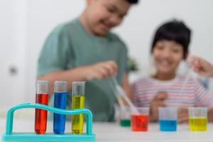 Aziatische kinderen kijken enthousiast naar scheikunde-experimenten. foto