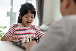 kleine jongen en meisje spelen thuis schaken. kinderen schaken foto