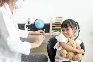 succesvolle covid-19-vaccinatie. schattig klein meisje terwijl ze wordt ingeënt tegen het coronavirus foto