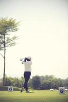 golfers slaan in de zomer een uitgestrekte golfbaan op. vintage kleur foto