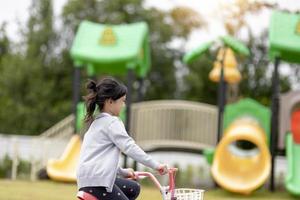 gelukkig vrolijk kind meisje fietsen in het park in de natuur foto