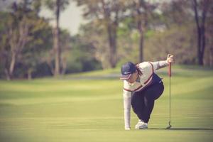 pro golfspeler gericht schot met club op course.golfer op putting green op het punt om het schot te nemen foto