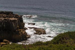 de golven die vechten om de verlaten rotskust van de Atlantische Oceaan, portugal foto