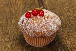 zoete smakelijke muffin met rode aalbessen foto