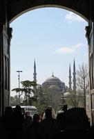 istanbul, turkije, 8 april 2015 - een menigte beweegt zich door een open deur naar het gebied waar de sultan ahmed-moskee op de achtergrond te zien is. foto