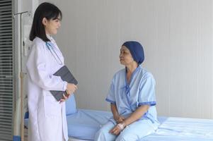 kankerpatiënt vrouw met hoofddoek na chemotherapie consultatie en bezoekende arts in het ziekenhuis.. foto