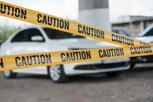 verboden gebied. gele waarschuwingstape in de buurt van de parkeerplaats overdag. plaats delict foto