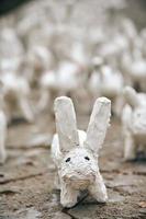 witte konijnenbeelden gemaakt van gips close-up, kunsttentoonstelling in de buitenlucht, kunstmatige witte hazen foto