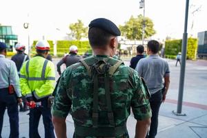 de rug van een soldaat met mannelijke politieagenten en bewakers op de achtergrond, stond in de rij te wachten op de commandant. foto