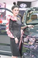 nonthaburi, thailand - 3 dec 2019 - niet-geïdentificeerd model poseert met een auto op de 36e motor expo thailand 2019 in impact arena, muang thong thani, nonthaburi, thailand. foto