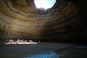 Faro, Portugal-14 augustus 2017 mensen op het strand in een grot in de prachtige kust van de Algarve van Portugal tijdens een zonnige dag foto