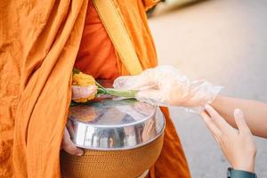 het aanbieden van aalmoezen aan monniken in de ochtend in Chiang Khan, Loei Province foto