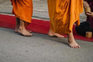 monniken lopen 's ochtends voor een aalmoes in chiang khan, loei provincie, thailand foto