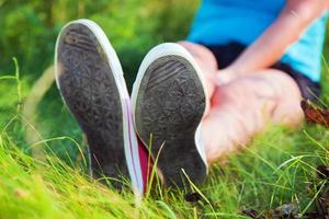 roze sneakers op meisjesbenen op gras foto