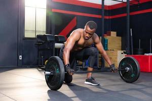 fitness man tillen gewichten in sportschool fitness, gespierde man trainen in sportschool oefeningen doen met barbell gewicht foto