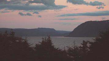 bergen gezien vanaf een afstand tijdens zonsondergang vanaf hertenmeer, newfoundland, canada foto