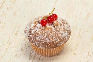 zoete smakelijke muffin met rode aalbessen foto