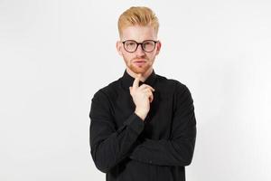 portret van knappe roodharige man op zwart, hipster poseren geïsoleerd op wit, geïsoleerde studio shot van jonge knappe roodharige hipster man die serieus en peinzend naar de camera kijkt. foto