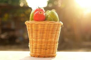 verse tomaten en pompoen in een mand gemaakt van bamboebladeren. foto