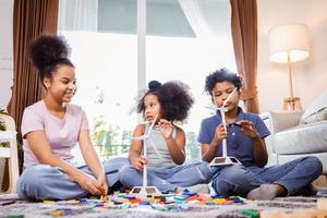 Afro-Amerikaanse kinderen ontspannen en spelen in de woonkamer op de vloer in een weekend foto