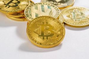 gouden munten met bitcoin cryptocurrency-symbool op witte achtergrond foto