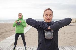 groep jongeren die buiten traint, hardlopersoefeningen, zee- of rivierachtergrond foto