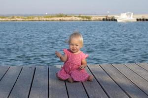 klein meisje in roze jurk bij de rivier foto