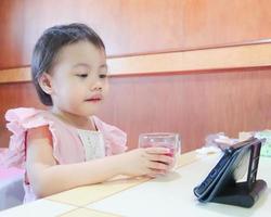 3 jaar oud aziatisch klein meisje student online leerklas studeren online in zoom met mobiele telefoon thuis. foto