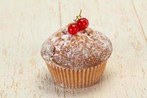 zoete smakelijke muffin met rode aalbessen foto