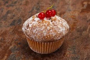 zoete smakelijke muffin met rode aalbessen foto