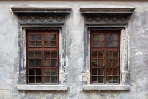 twee ramen op een oude grijze stucwerkmuur. foto