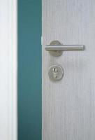 geopende deur met metalen deurknop in blauwe kamer foto