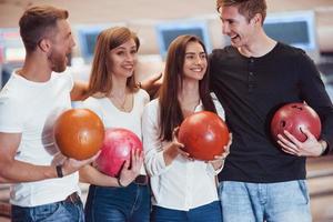 actief gesprek. jonge vrolijke vrienden hebben plezier in de bowlingclub in hun weekenden foto