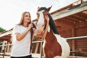 laten we gaan rennen. gelukkige vrouw met haar paard overdag op de ranch foto