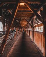 man loopt op houten brug foto