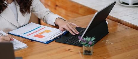 close-up van zakenvrouwen of accountant die laptop gebruiken terwijl ze analytisch bedrijfsrapport op de werkplek werken, financieel en boekhoudkundig concept plannen foto