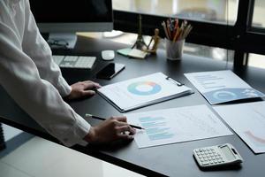 zakenvrouw die rekenmachine gebruikt om wiskunde te financieren op houten bureau in kantoor en zakelijke achtergrond, belasting, boekhouding, statistiek en analytisch onderzoeksconcept foto