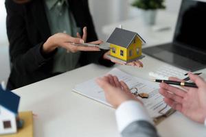 makelaar bood huisverkoop aan en legde de voorwaarden uit voor het ondertekenen van het huisaankoopcontract en gratis huisverzekering, financiën en after-sales serviceconcept foto