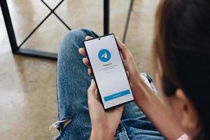 vrouw hand met samsung s22 ultr met telegram voor sociale netwerken op het scherm. foto