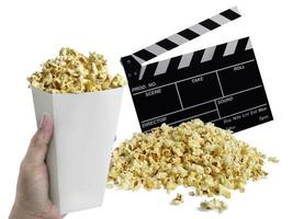 hand met popcorn, film Filmklapper op wit wordt geïsoleerd foto