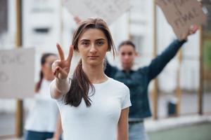 vrienden op de achtergrond. groep feministische vrouwen protesteert buiten voor hun rechten foto