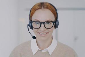 vriendelijke vrouw in koptelefoon in callcenter. gezicht van gelukkige werknemer. klantenondersteuningsconcept. foto