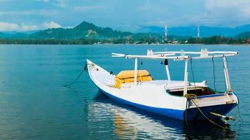 een motorboot gebruikt door vissers. reis bij pasangkayu-strand in pasangkayu-regentschap, indonesië. tropisch landschap met motorboot. schilderachtige achteraanzicht motorboot schip op schoon blauw zeewater. foto