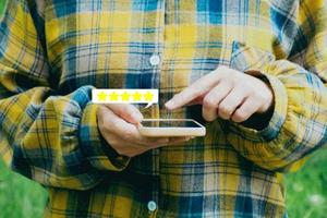 vrouwenhanden met een telefoonproductkwaliteitsbeoordeling vijf sterren, close-up foto