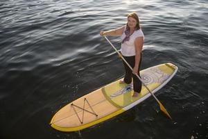 mooie vrouw paddle boarding foto