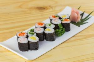 maki sushi set in een witte plaat op een houten vloer foto