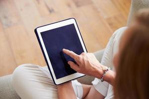 sluit omhoog van vrouw thuis gebruikend digitale tablet