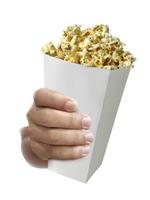 hand met popcorn, in de hand geïsoleerd op een witte achtergrond foto