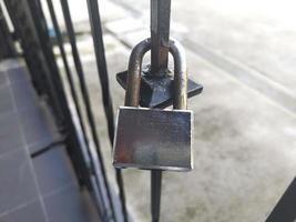 oud gesloten hangslot dat aan de ouderwetse metalen poort hangt foto